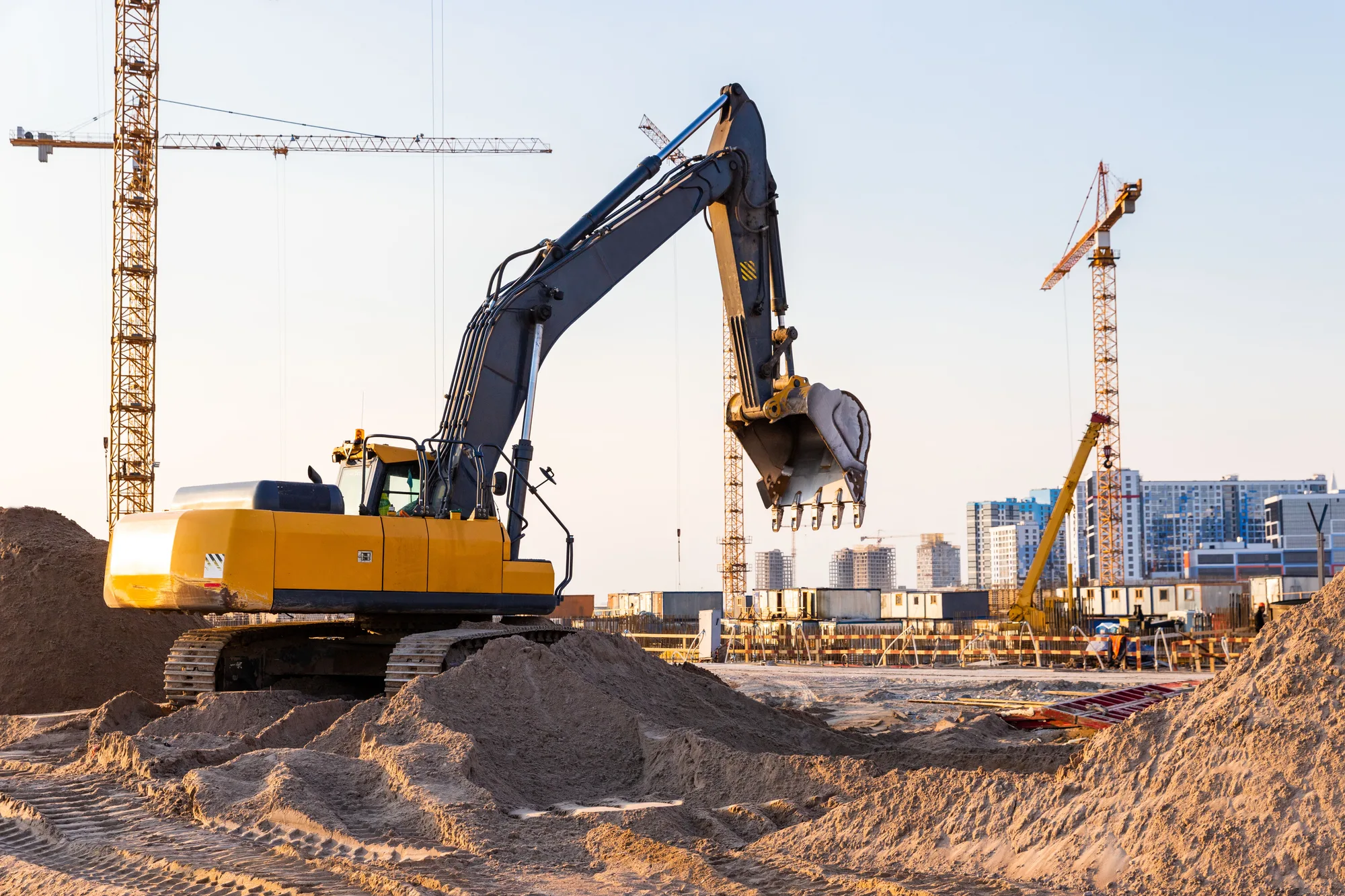Grúas y excavadoras en obra al atardecer